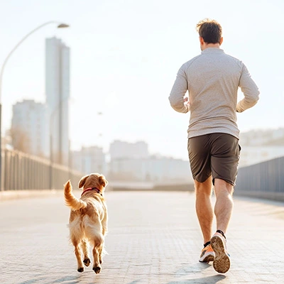 man running with dog through the city